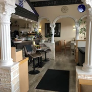 Restaurant Olympia  Restaurant mit klassisch-griechischen Säulen und einladender Atmosphäre innen; Bar und Sitzbereiche.