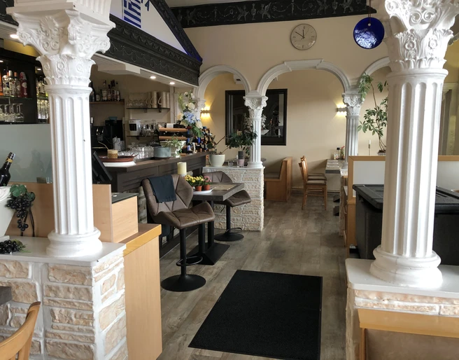 Restaurant Olympia  Restaurant mit klassisch-griechischen Säulen und einladender Atmosphäre innen; Bar und Sitzbereiche.