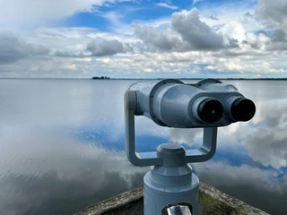 Beobachtungsturm Winzlarer Turm Teleskop am Winzlarer Turm mit weitem Blick auf den wolkigen, spiegelnden See an einem klaren Tag.