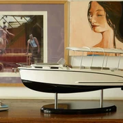 Canito l'acqua - Exklusive Bootfahrt in Leipzig Das Modell eines Bootes steht auf einem Sideboard, im Hintergrund hängen zwei Kunstwerke