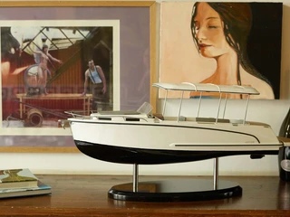 Canito l'acqua - Exklusive Bootfahrt in Leipzig Das Modell eines Bootes steht auf einem Sideboard, im Hintergrund hängen zwei Kunstwerke