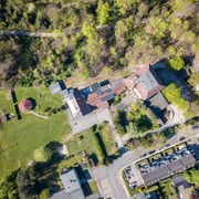 Das Gelände der Jugendherberge Velbert von oben Luftaufnahme der Jugendherberge Velbert, umgeben von viel Grün, nahe einem Sportplatz und einer Straße.