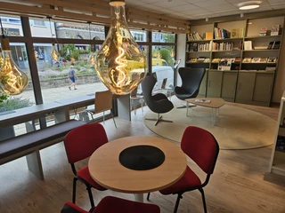 Bad Driburg_Stadtbücherei-2.jpeg Inneneinrichtung einer modernen Bibliothek mit gemütlichen Sitzbereichen und einer großen Fensterfront.