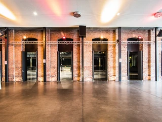 Palladium Köln Foyer Das Palladium Köln Foyer zeigt sich mit industriellem Flair. Sichtbares Mauerwerk, hohe Bögen und moderne Lichtelemente verleihen dem Raum eine besondere Atmosphäre.The Palladium Cologne foyer has an industrial flair. Visible brickwork, high arches and modern lighting elements give the room a special atmosphere.