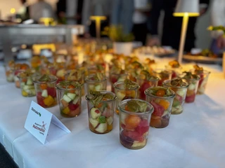 Business Buffet Catering Ansprechend präsentiertes Buffet mit kleinen Gläsern gefüllt mit buntem Obstsalat, beleuchtet und stilvoll angerichtet.Attractively presented buffet with small glasses filled with colorful fruit salad, illuminated and stylishly arranged.