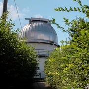Blick auf die Kuppel der Sternwarte zwischen Büschen.