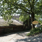 Örkhof mit Hofladen Velbert Eingang zum Örkhof mit Hofladen in Velbert, umgeben von grünen Bäumen und ländlichen Gebäuden.