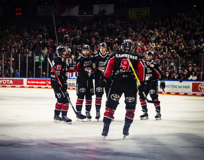Kölner Haie Fünf Eishockeyspieler der Kölner Haie stehen in voller Ausrüstung auf dem Eis in der Lanxess Arena.Five Cologne Sharks ice hockey players in full gear on the ice in the Lanxess Arena.