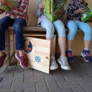 Kinder schauen sich Bücher aus der Bücherkiste an.