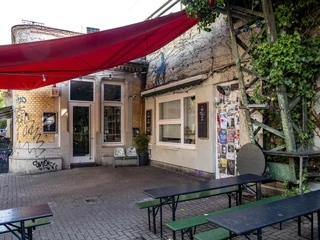 Zum Scheuen Reh Ein kleines, gemütliches Lokal mit Grafitti-kunst dekorierter Fassade und überdachtem Außenbereich.A small, cozy restaurant with a facade decorated with graffiti art and a covered outdoor area.