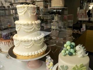Madame Miammiam Drei Torten mit kunstvollen Verzierungen stehen im Schaufenster einer Konditorei.Three cakes with elaborate decorations are displayed in the window of a patisserie.