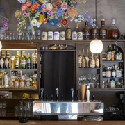 Forelle Blau Barbereich mit farbenfrohem Blumenschmuck und diversen Getränken; warmes und einladendes Ambiente.Bar area with colorful floral decorations and various drinks; warm and inviting ambience.