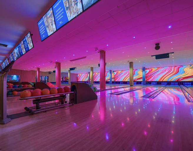 Bowling lanes at West Bowling Eine moderne Bowlinghalle mit farbenfroher LED-Beleuchtung, leuchtende Bahnen und bunte Kugeln.A modern bowling hall with colorful LED lighting, glowing lanes and colorful balls.