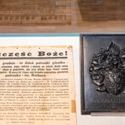 Barbaratag Glasvitrine mit historischem Dokument und Gedenkplakette zur Heiligen Barbara im Museum ausgestellt.