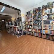 Brave New World entrance area Ein lichtdurchfluteter Raum voller Gesellschaftsspiele, die in hohen Regalen perfekt zur Schau gestellt sind.A light-flooded room full of board games, perfectly displayed on high shelves.