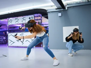 7th Space Cologne Zwei Personen mit Virtual-Reality-Headsets und Controllern tauchen in eine immersive VR-Erfahrung ein.Two people with virtual reality headsets and controllers immerse themselves in an immersive VR experience.