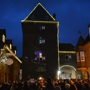 Turmblasen am Schelmentur Eine große Menschenmenge versammelt sich vor einem beleuchteten Turm zum traditionellen Turmblasen.