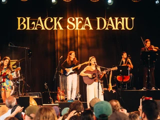Even Flow Festival 2025 Eine mögliche Beschreibung für das Bild ist: "Live-Auftritt der Band Black Sea Dahu auf großer Bühne, umrahmt von begeistertem Publikum."A possible description for the picture is: "Live performance by the band Black Sea Dahu on a large stage, surrounded by an enthusiastic audience."