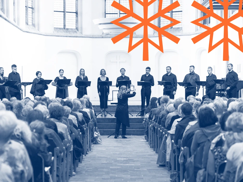 Musica Sacra Ukraina Das Bild zeigt ein Ensemble, das auf einer erhöhten Bühne im Inneren einer Kirche auftritt. Vor ihnen sitzt ein gefülltes Publikum, während ein Dirigent das Ensemble anleitet. Die Atmosphäre wirkt feierlich und konzentriert.The picture shows an ensemble performing on a raised stage inside a church. A full audience sits in front of them while a conductor leads the ensemble. The atmosphere is solemn and concentrated.