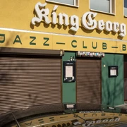 King Georg King Georg Jazzclub mit gelber Fassade und geschlossenen Rollläden, Köln bei Tageslicht.King Georg Jazzclub with yellow facade and closed shutters, Cologne by daylight.