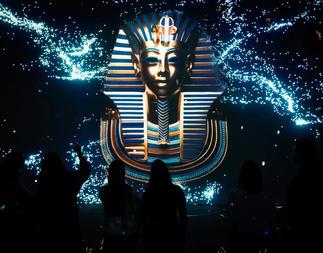 Tutankhamun - His Tomb and His Treasures Die beeindruckende Maske des Tutanchamun leuchtet eindrucksvoll vor dunklem Hintergrund.The impressive mask of Tutankhamun glows impressively against a dark background.