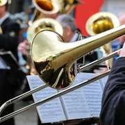 Posaunenchor Ein Posaunenchor spielt im Freien, glänzende Instrumente reflektieren das Licht.