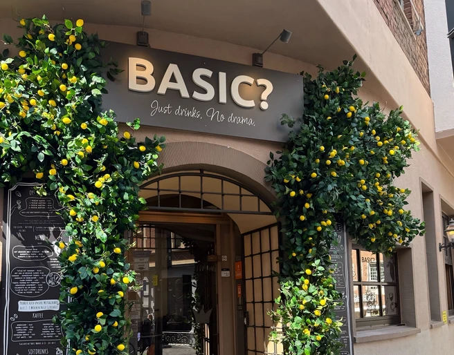 Bogenförmiger Eingang der BASIC? Gastrobar, flankiert von Zitronenbäumchen.