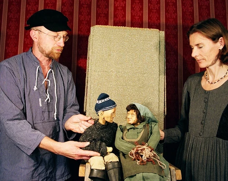 figurentheater-ernst-heiter-vom-fischer-und-seiner-frau.jpg Zwei Personen führen Holzpuppen im Märchen „Vom Fischer und seiner Frau“ vor rotem Bühnenhintergrund.