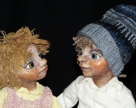 annes-buehne-der-prinz-mit-den-eselsohren-2.jpg Zwei handgefertigte Puppen blicken sich an, eine mit Strickmütze, die andere mit strubbligem Haar.