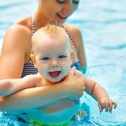 Baby u. Kleinkinderschwimmen im Koppke Greetsiel  Zu sehen ist ein Baby auf dem Arm der Mutter im Schwimmbecken