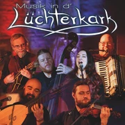Titelbild Musik in der Lüchterkark.jpg Auf dem Bild ist eine Gruppe von Musikern mit traditionellen Instrumenten vor einem beleuchteten Hintergrund.