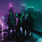 Eine Gruppe von fünf Personen steht im Vordergrund einer nächtlichen Großstadt mit neonbeleuchteten Hochhäusern.