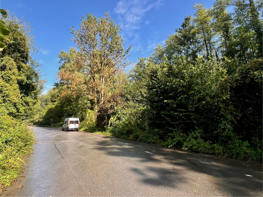 Wohnmobilstellplatz am Steinbruch in Haan-Gruiten Wohnmobil-Stellplatz an einer von Bäumen umgebenen Straße in Haan-Gruiten.