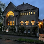 Lessing-loge-Logenhaus-Abend.jpg Außenansicht des Logeshauses am Abend mit beleuchteten Fenstern