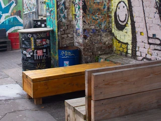 Helios37 outdoor area Graffiti auf Backsteinwand in urbanem Hof mit bunter, kreativer Straßenkunst und Sitzmöglichkeiten.Graffiti on a brick wall in an urban courtyard with colorful, creative street art and seating.