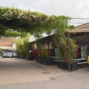 Live Music Hall Außenbereich der Live Music Hall mit bunten Graffiti, Bambuspflanzen und Sitzmöglichkeiten.Outdoor area of the Live Music Hall with colorful graffiti, bamboo plants and seating.