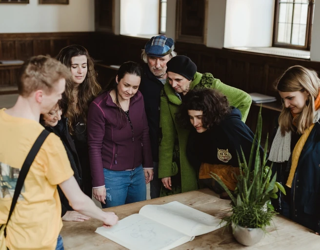 Rathaus- und Altstadt (Hauptbild).jpg Eine Gruppe interessierter Besucher studiert gemeinsam einen alten Stadtplan in einem historischen Gebäude.A group of interested visitors study an old city map together in a historic building.Een groep geïnteresseerde bezoekers bestudeert samen een oude stadsplattegrond in een historisch gebouw.
