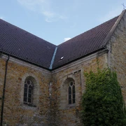 Gertrudenberg (Hauptbild).jpg Historische Kirchenmauer aus Backstein, flankiert von Fenstern mit gotischem Stil, bewachsen mit Efeu.Historic brick church wall, flanked by Gothic-style windows, overgrown with ivy.Historische bakstenen kerkmuur, geflankeerd door ramen in gotische stijl, overwoekerd door klimop.