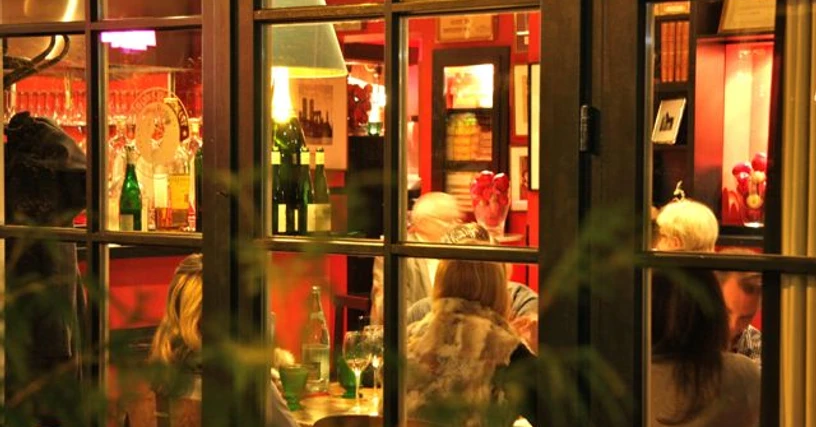 Weihnachtlich1.jpg Ein Blick durch Fenster auf ein festlich beleuchtetes Restaurant mit Gästen am Tisch.A view through the window of a festively lit restaurant with guests at the table.