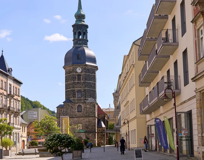 Kirche Bad Schandau am Marktplatz Straßenszene mit Personen, Kirchturm und historischen Gebäuden bei Sonnenschein am Marktplatz Bad Schandau.