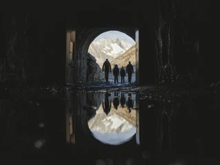 Sortie par le tunnel du Tälligrat Teilnehmer der Aletschgletscher Rundtour verlassen den Tälligrattunnel mit Blick auf verschneite Berge und FelsenParticipants on the Aletsch Glacier round tour leave the Tälligrat Tunnel with a view of snow-covered mountains and rocksLes participants au circuit du glacier d'Aletsch quittent le tunnel du Tälligrat avec vue sur les montagnes et les rochers enneigés.