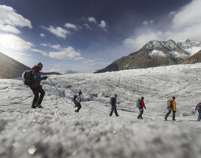Geführte Gruppe auf dem Aletschgletscher Eine Seilschaft von Personen wandert über das Eis des Aletschgletschers während der Gletschertour Jungfraujoch Märjelensee
