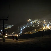 Fackelabfahrt mit Aussicht auf Bettmeralp Skifahrer fahren mit Fackeln bei Nacht ins Tal während des Mondscheinessen Aletsch Arena bei der Bettmeralp