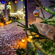 Adventsmarkt_Packhof_2024-1(1).jpg Einzigartig illuminierter Adventsmarkt mit Weg aus Kopfsteinpflaster, festliche Dekoration durch Tannenzweige und Lichterketten.