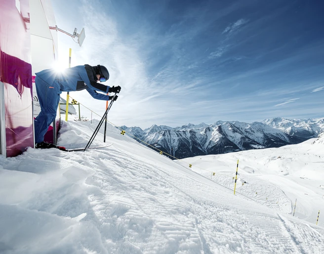 Skifahrer am Start der Speedstrecke Skifahrer in Rennposition startet an der Speedstrecke der Fiescheralp während der Glacier Challenge Skiline Aletsch Arena