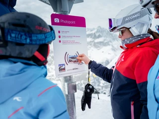 Skiline Fotopoint Eggishorn Skifahrerin scannt ihre Karte am Fotopoint beim Eggishorn während der Glacier Challenge Skiline Aletsch Arena