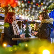 Vier junge Frauen beim Glühweintrinken in weihnachtlicher Atmosphäre auf dem Acherner Weihnachtsmarkt