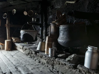 Alte Kessel und Werkzeuge in der Sennküche Schaukäsen Alpmuseum Aletsch zeigt historische Kupferkessel und Werkzeuge zur traditionellen Käseherstellung