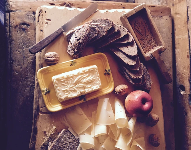 Traditional alpine butter with Valais rye bread Schaubuttern Alpmuseum Aletsch mit Butter, Roggenbrot, Käse und Nüssen als typische Walliser AlpkostAletsch Alpine Museum show churns with butter, rye bread, cheese and nuts as typical Valais Alpine fareGrille de présentation du musée d'alpage d'Aletsch avec beurre, pain de seigle, fromage et noix comme nourriture typique de l'alpage valaisan