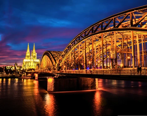 RikoloniaDomTeamlicht.png Hell erleuchtete Hohenzollernbrücke und Kölner Dom bei Nacht.Brightly lit Hohenzollern Bridge and Cologne Cathedral at night.